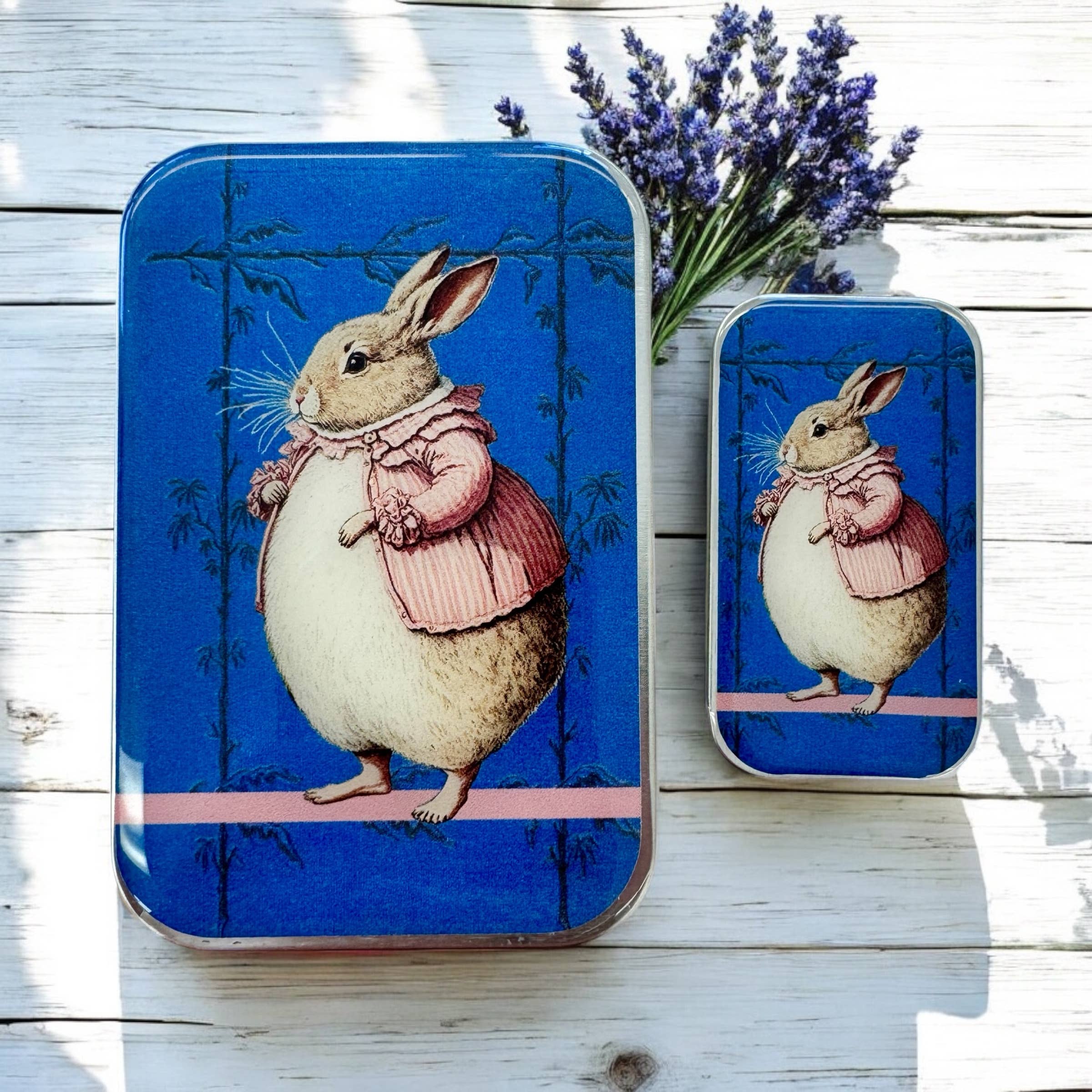 Firefly Notes’ Lady Bunbury, Bunny Notions Tin: Small features a hand-resined rabbit in a pink coat on a blue background, with matching rectangular tins and lavender on a white wooden surface.