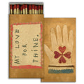 HomArt’s Match - My Love For Thine features red-tipped safety matches, a box with “MY LOVE FOR THINE” in handwritten script, and an illustration of a hand with a heart and clover—perfect as a charming hostess gift.