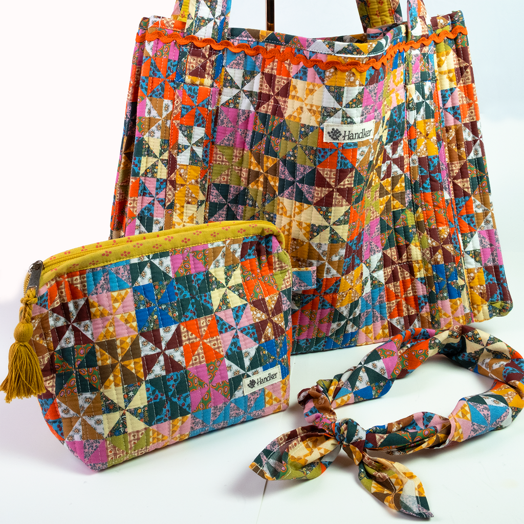 The Calico Quilted Tote by Handker Bandanas features a bright bandana cotton patchwork, includes a matching yellow-trim pouch with tassel, and comes with a fabric headband in geometric patterns on white.