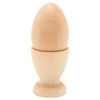 The Wooden Egg Cup Holder by Woodpeckers Crafts displays a smooth, unfinished wooden egg upright in a plain, flat-bottom holder, both with simple designs on a white background.