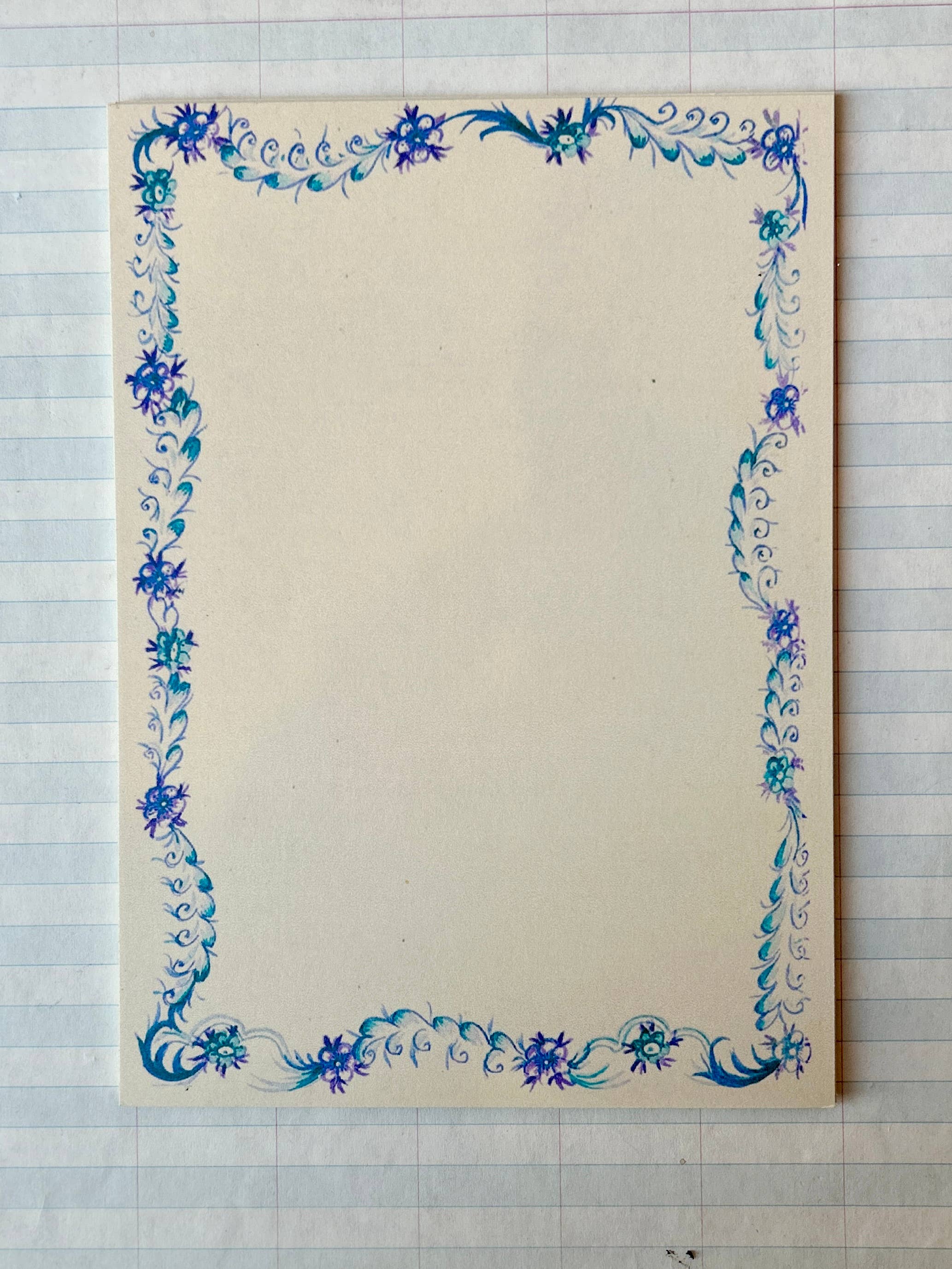 The French Menu Stationery Set II: 2 by Parcel features creamy white blank cards with a blue and purple floral border, set atop lined paper. Available in a set of 8.
