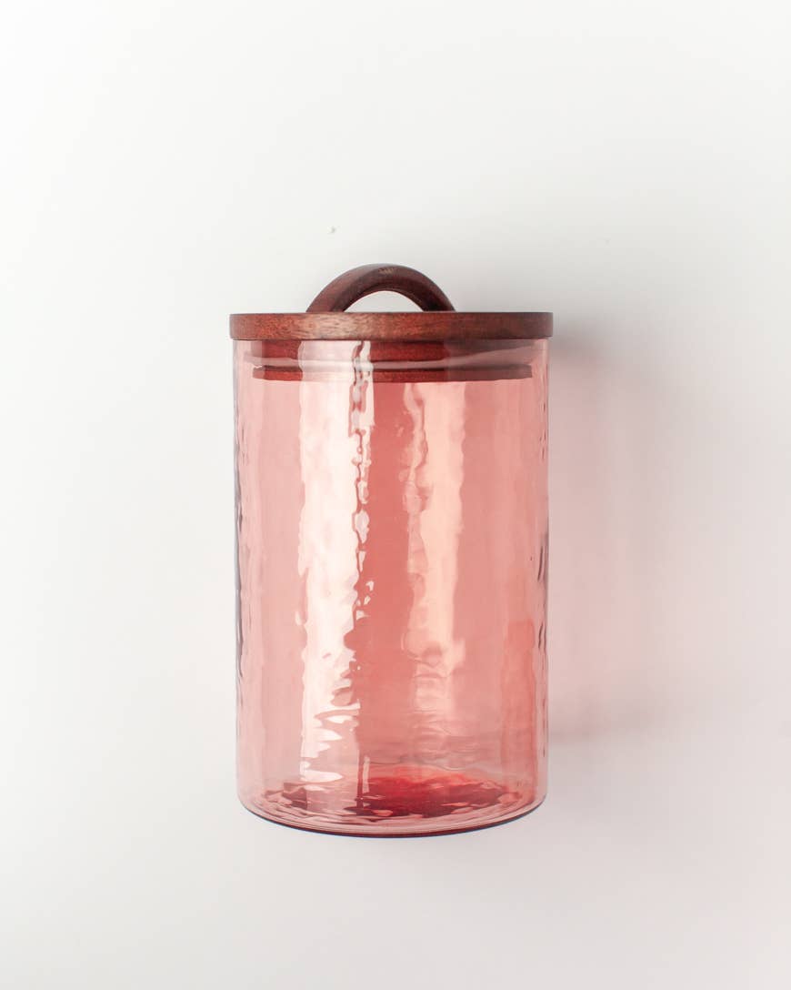 The Handblown Hammered Glass Canisters: Smoke / Small by Creative Women is a tall, cylindrical smoked glass jar with a hand-carved wooden lid and rounded handle, shown against a plain white background.