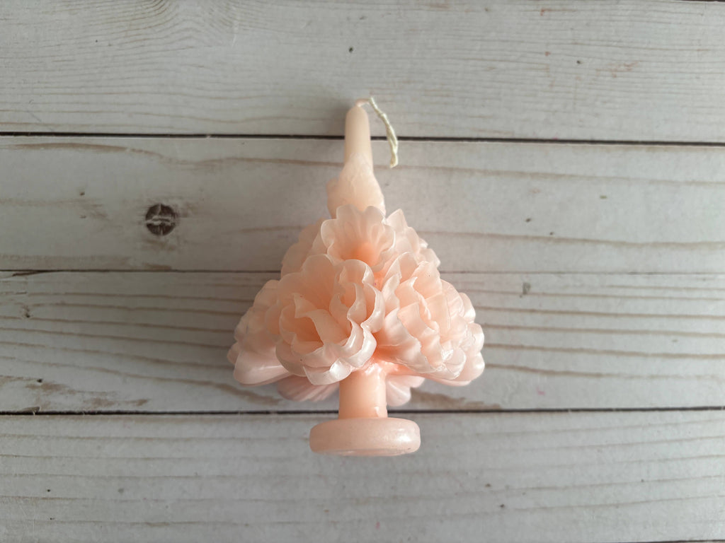 Light pink Carnation Oaxaca Marigold Day of the Dead Candle molded into the shape of a ruffled flower cluster.