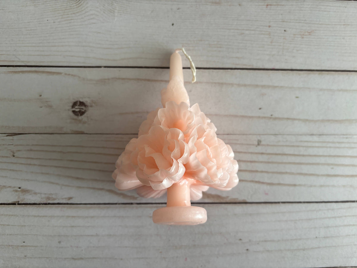 Light pink Carnation Oaxaca Marigold Day of the Dead Candle molded into the shape of a ruffled flower cluster.
