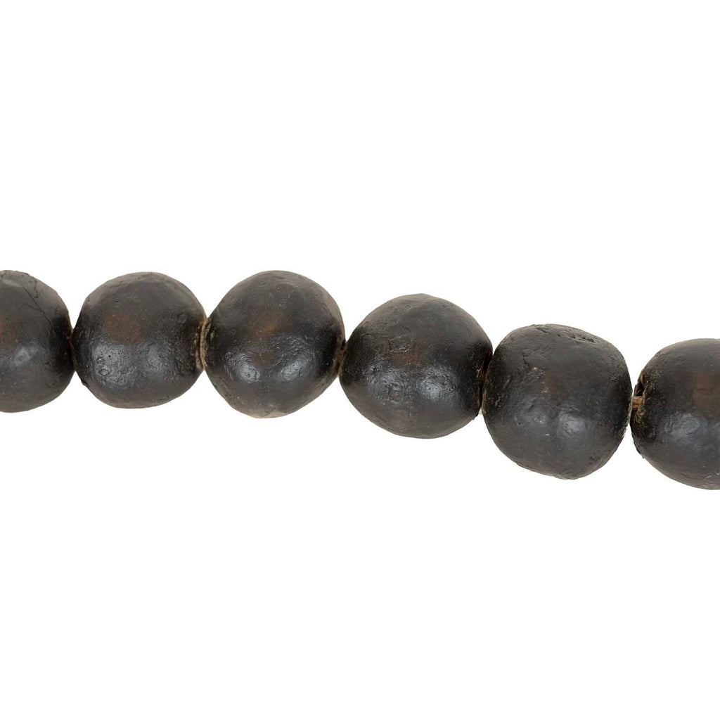 A close-up of the Foreside Home & Garden Black Terracotta Bead + Jute Garland, featuring round, matte black terracotta beads with slightly irregular surfaces, threaded together in a row.