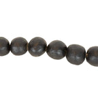 A close-up of the Foreside Home & Garden Black Terracotta Bead + Jute Garland, featuring round, matte black terracotta beads with slightly irregular surfaces, threaded together in a row.