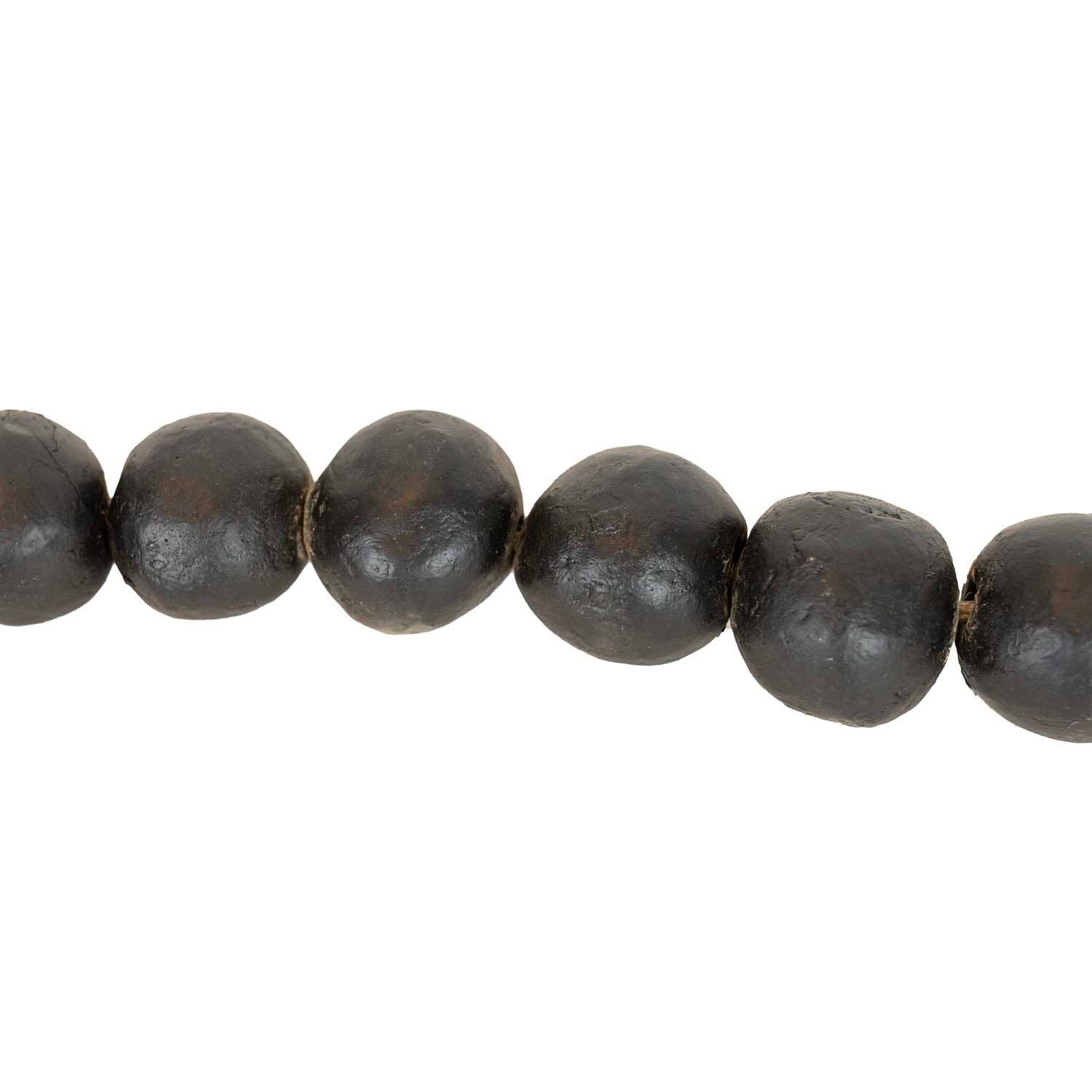 A close-up of the Foreside Home & Garden Black Terracotta Bead + Jute Garland, featuring round, matte black terracotta beads with slightly irregular surfaces, threaded together in a row.