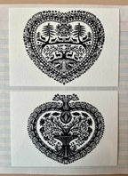 Parcel’s Papercut Heart Art Cards set features two 5x7 intricate black paper cuttings: one heart-shaped with trees, animals, and florals; the other with a central tree and floral motifs. Each comes with a creamy white envelope.