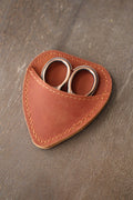 The NNK Press Mini Scissor Keepers: Chestnut features small metal embroidery scissors in a stitched brown leather pouch—ideal for your knitting bag.