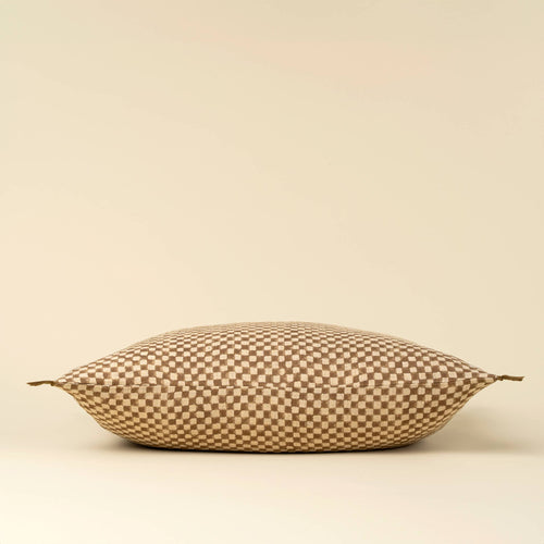 The Indaba Trading 16x24 Block Print Check Linen Pillow in brown features a soft, rectangular Belgian linen cover with a brown and beige checkerboard pattern, small fabric ties at each corner, and comes complete with filler.