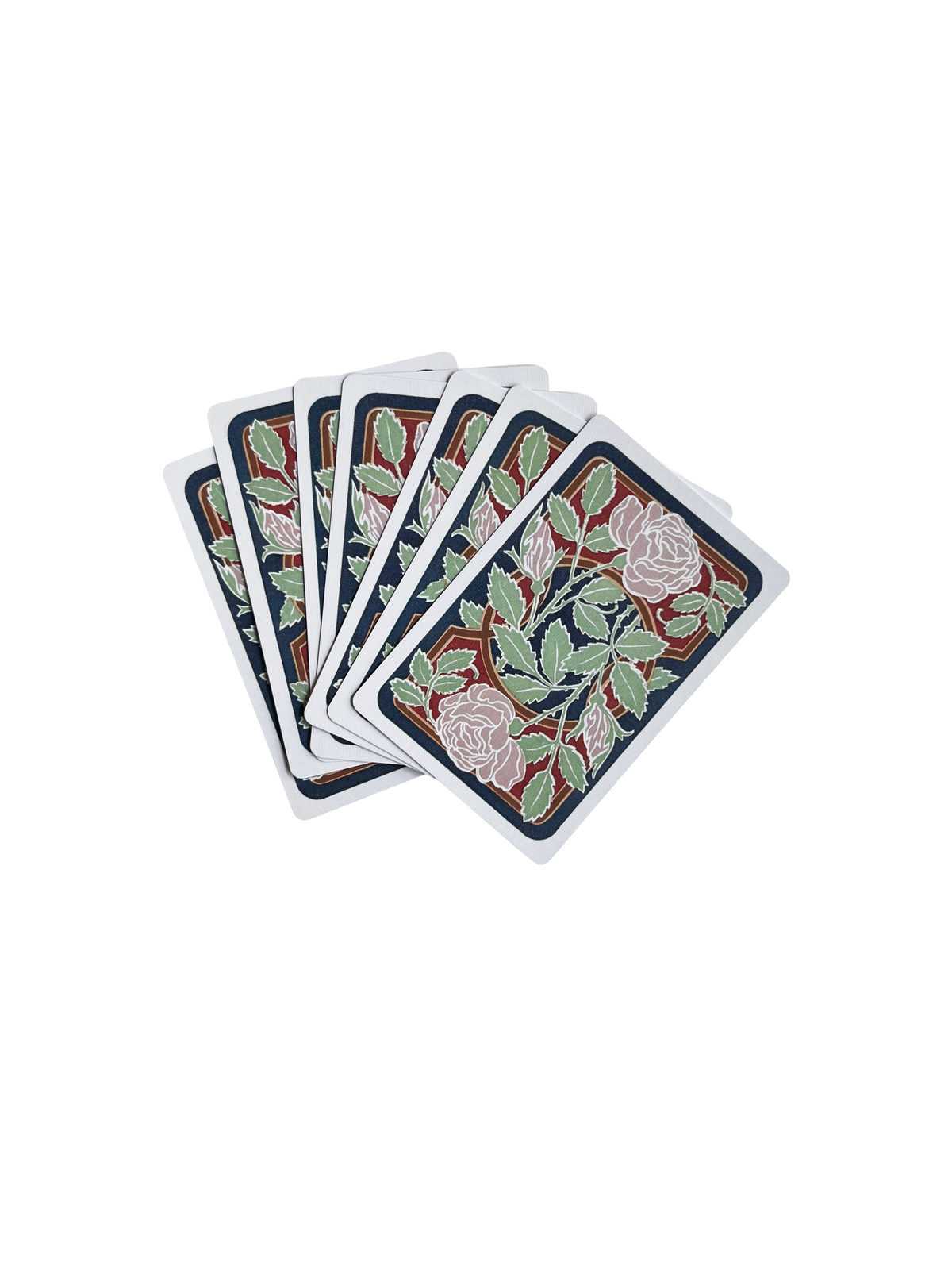 Seven G. Quenioux Playing Cards - 1900 Paris Exposition Facsimile by Vieux Monde are fanned out, their backs showing elegant roses and green leaves, capturing the refined style of Belle Époque Paris.