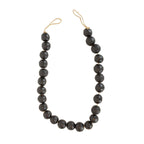 The Foreside Home & Garden Black Terracotta Bead + Jute Garland features large, round black terracotta beads and natural jute rope—offering a handmade Indian-inspired decor accent for your space.