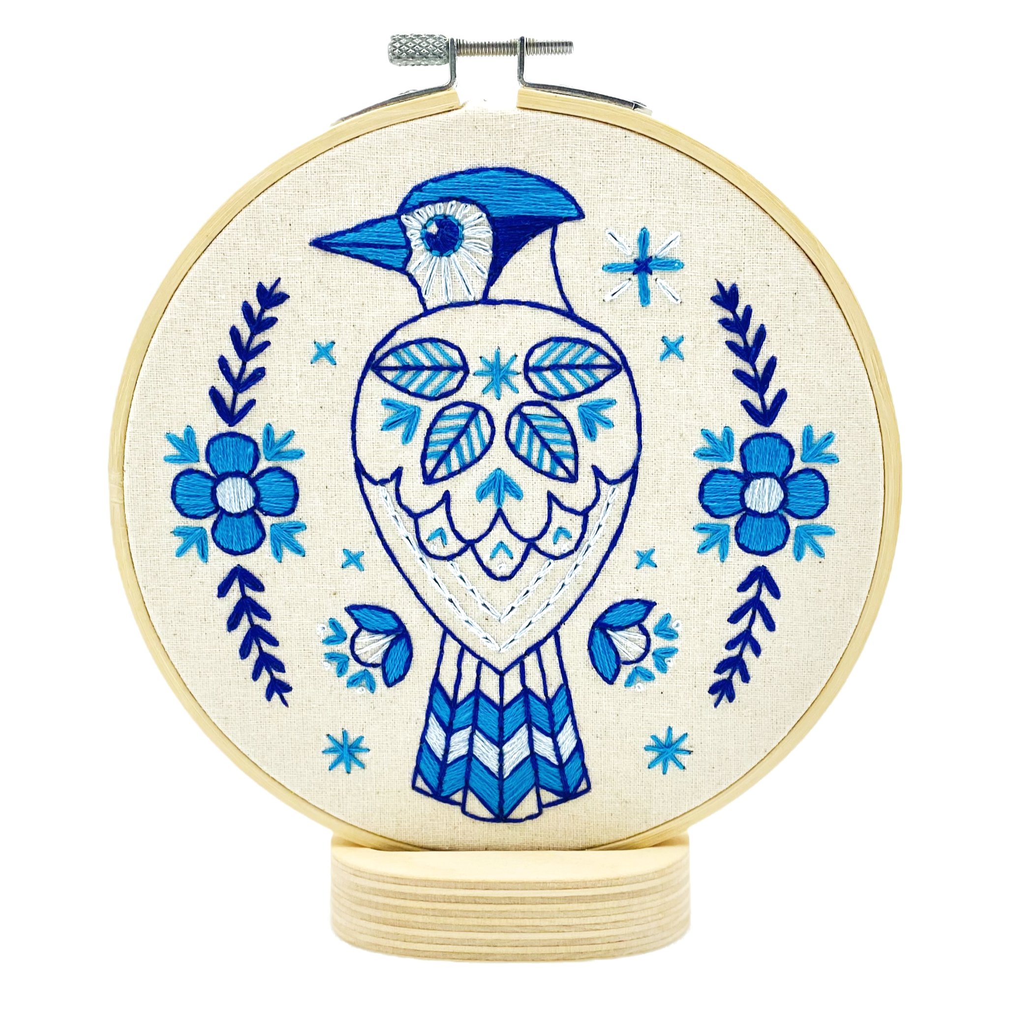 The Blue Jay Complete Embroidery Kit by Hook, Line & Tinker features a blue and white stylized bird with floral and geometric details—an ideal beginner project for embroidery enthusiasts.