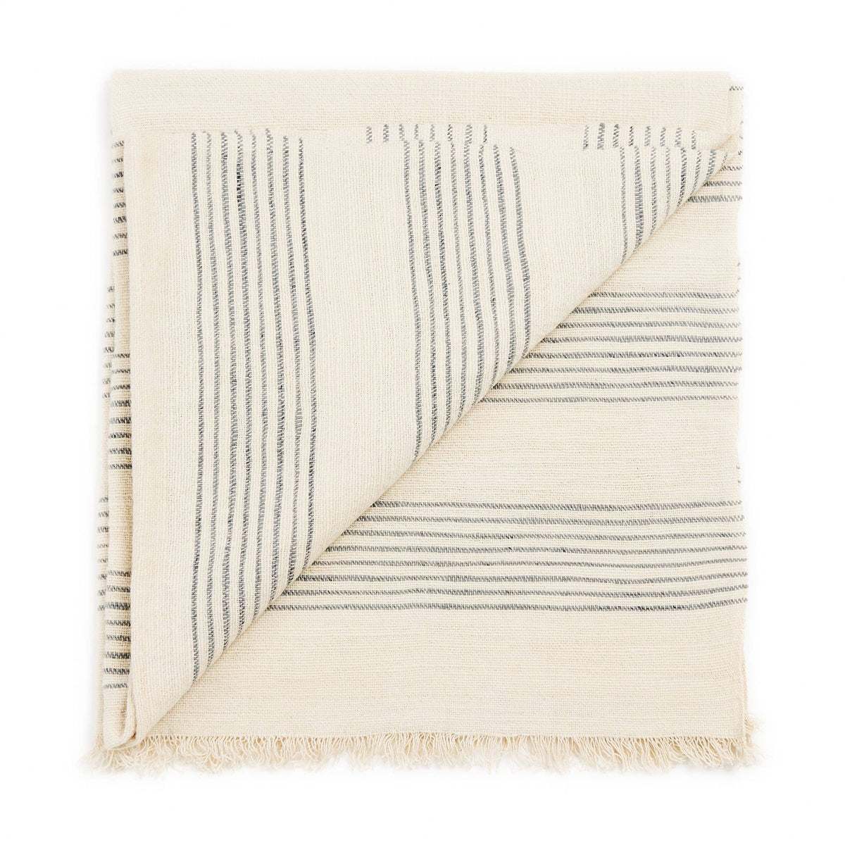 A folded, artisan-made Variously Silica Rose Throw in a salmon rose hue, featuring thin horizontal gray stripes and fringed edges, is shown with one corner flipped to reveal the underside.