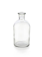 The Jamali Garden Clear Medicine Bottle Bud Vase features a short neck and wide mouth, standing upright on a white background—ideal as a unique flower vase or stylish accent for your home decor.
