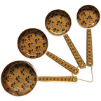 Four brown ladles with black and white leaf designs fan out, joined by a gold chain—Zest Enameled Steel Measuring Cups Set of 4 by Danica Heirloom adds elegance to any kitchen.