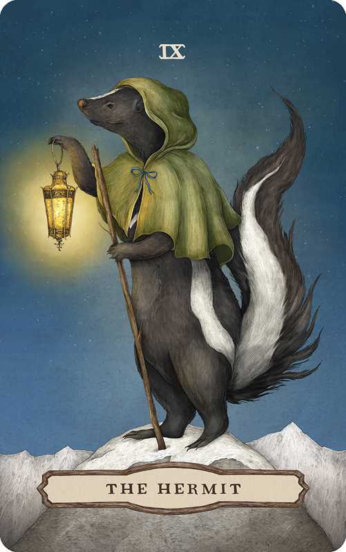 A skunk in a green cloak stands atop a snowy mountain, holding a lantern and staff as The Hermit card from the Tarot of the Woodland Wardens by Jessica Roux. The scene—under a starry sky with mountains in the distance—reflects the enchanting nature-inspired artwork of this 224-page mixed media tarot deck (Simon & Schuster), evoking themes of solitude and wisdom amid the wilderness.