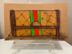 A hand-drawn illustration by Brooklyn artist Rachel Nelson of the Guch wallet, featuring a brown and tan pattern, green and red stripe, and GG logo, displayed on a clear stand. Brand: Thyne Goods.