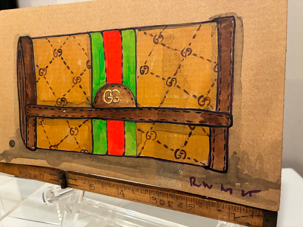 Rachel Nelson • Guch by Thyne Goods is a hand-drawn illustration of a designer-style clutch with a brown body, interlocking G patterns, green and red stripe, and brown accents, displayed on a wooden ruler stand.