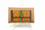Rachel Nelson • Guch by Thyne Goods: Brooklyn artist’s drawing of a brown designer clutch with green-red stripe and “GG” logos on a clear easel. Bold neon flower style pops against a white background.