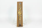 A hand-drawn illustration titled "Rachel Nelson • Watch" by Thyne Goods features a gold and silver wristwatch on brown paper, set upright on a clear easel against a white background, reflecting Rachel Nelson's refined style.