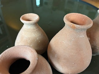 The HomArt Tiny Terra Cotta Vases – Set of 5 features small, round vessels with narrow necks in earthy, weathered finishes and a subtle speckled texture, beautifully arranged on a reflective dark surface.
