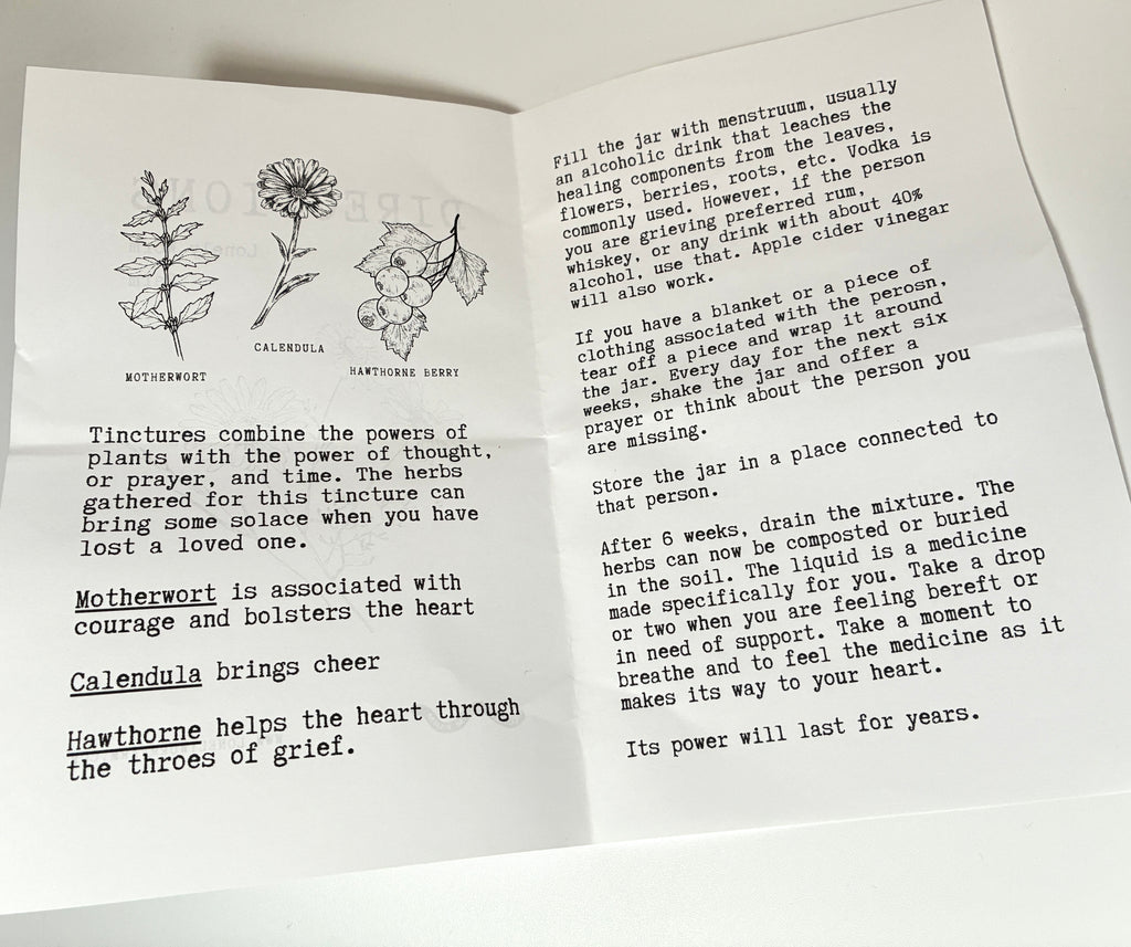 The Grief Kit from Lonely Worm Farm features an open booklet displaying illustrations of motherwort, calendula, and hawthorn berry, accompanied by clear instructions and information on creating a tincture with these heart-supporting herbs—making it a perfect inclusion in any remembrance kit or as a meaningful grief gift.