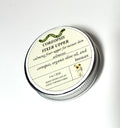 A round tin labeled Coreopsis Fixer Upper from Lonely Worm Farm by Thyne Goods, formulated with coreopsis, organic olive oil, and beeswax, serves as a calming skin fixer for minor skin ailments.