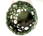 Introducing “Lettuce” by BMB—a green ceramic bowl featuring multiple round holes of varying sizes across its sides and bottom, forming an open, abstract design. This unique handmade clay vessel is ideal as an airplant bowl and is personally signed by the artist for a distinctive touch.