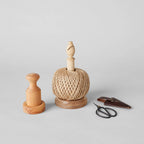 The Bloomist Gardener's Planting Set (One Size), featuring a spool of twine on a wooden holder, a wooden tamper, and floral scissors with leather sheath, is displayed on a light gray surface.