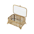 The Filigree Box by Silver Tree Home & Holiday features ornate gold filigree, decorative feet, a hinged lid with inner mirror, floral side patterns, and a mirrored base—shown against a white background.