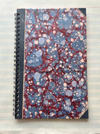 The Parcel Antique Endpaper Notebook: Large - Blue & Burgundy / Unlined features a marbled blue and burgundy cover, black spine and corners, and durable 110 cardstock—perfect for lasting use.