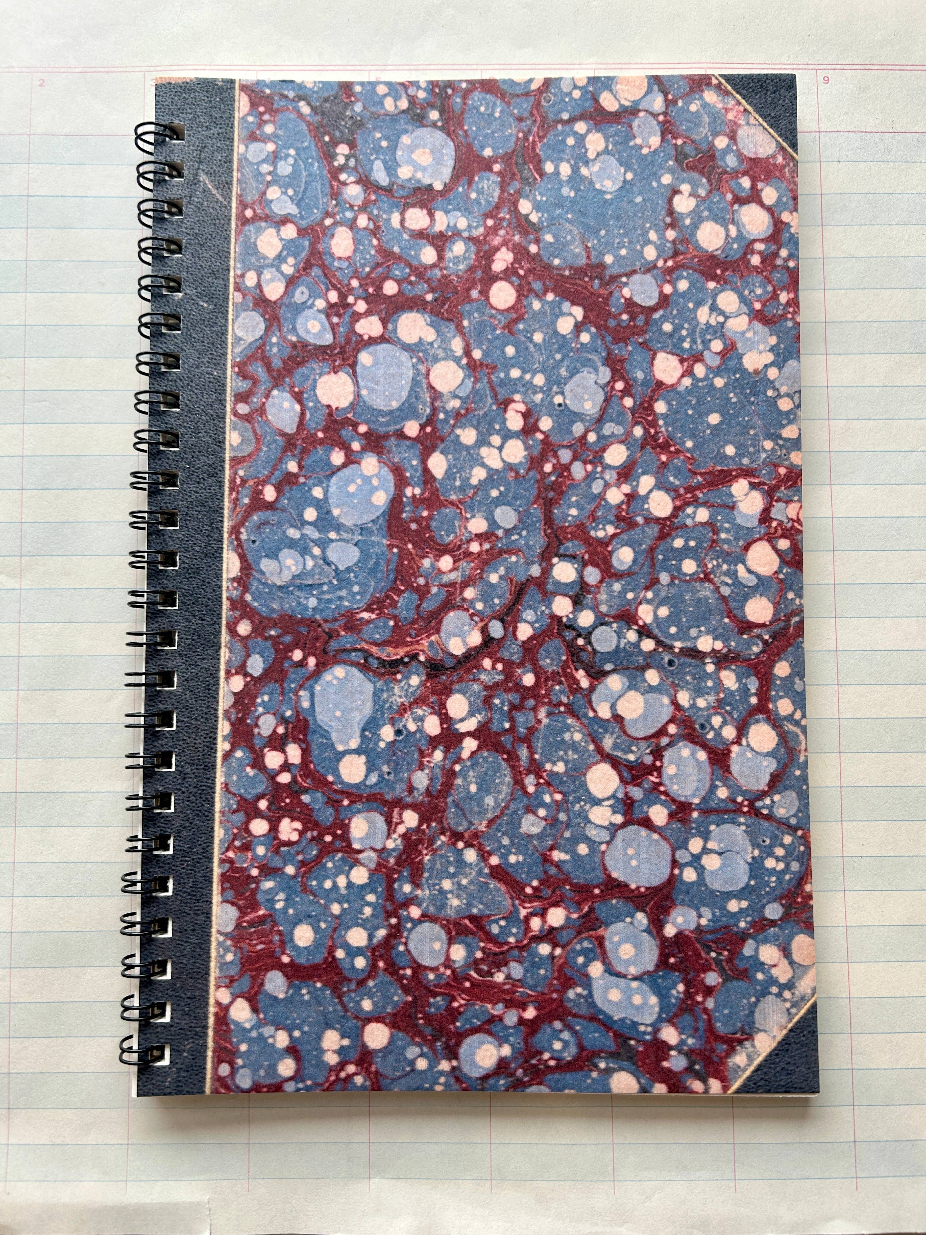 The Parcel Antique Endpaper Notebook: Large - Blue & Burgundy / Unlined features a marbled blue and burgundy cover, black spine and corners, and durable 110 cardstock—perfect for lasting use.