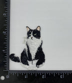 A Wholesale Applique Tuxedo Cat Kitten Pets iron on patch is displayed on a white surface beside a black ruler, showing the patch measures approximately 2 inches tall by 1.5 inches wide.