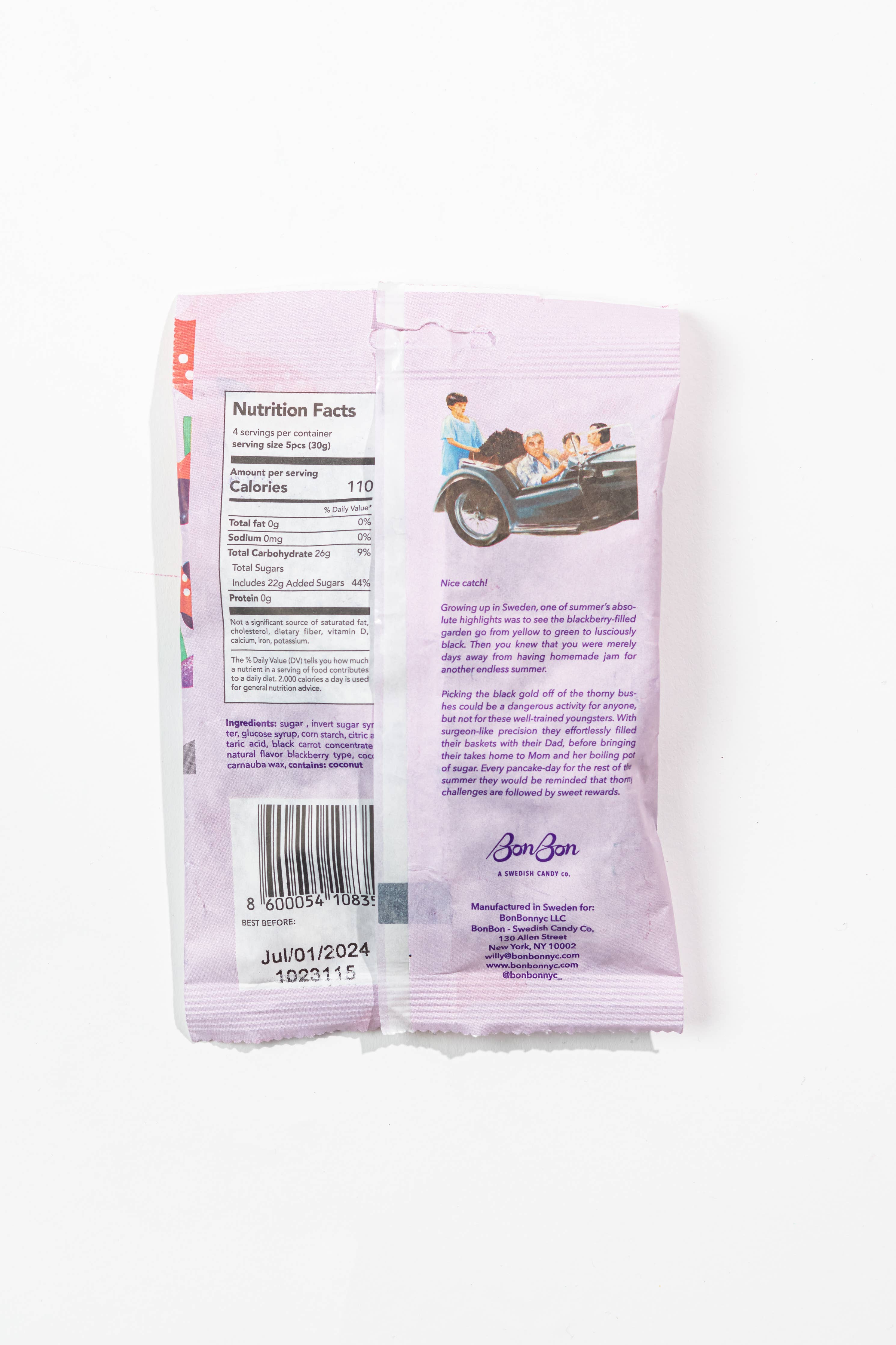 The back of the pastel purple Sour Blackberry Fish - Swedish Candy 5.2oz (150g) package by BonBon - A Swedish Candy Co features nutrition facts, a barcode, an expiration date, a vintage car with people inside, and product details.
