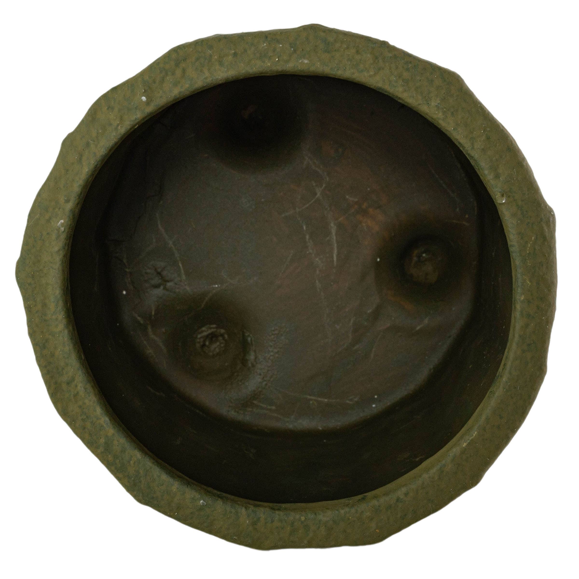 Top-down view of the Foreside Home & Garden Matte Green Ceramic Pot Small, featuring a greenish-brown, textured finish, an uneven rim, and three distinct dents on the bottom surface.