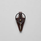 The Bloomist Gardener's Planting Set (One Size) features black metal floral scissors in a brown leather sheath with a brass button, displayed on a light gray background—a refined essential for any gardening collection.