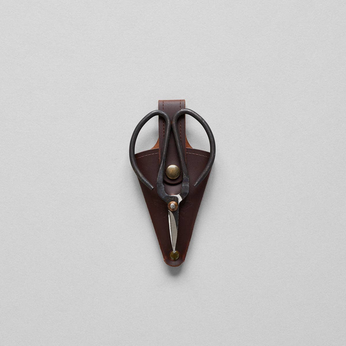 The Bloomist Gardener's Planting Set (One Size) features black metal floral scissors in a brown leather sheath with a brass button, displayed on a light gray background—a refined essential for any gardening collection.