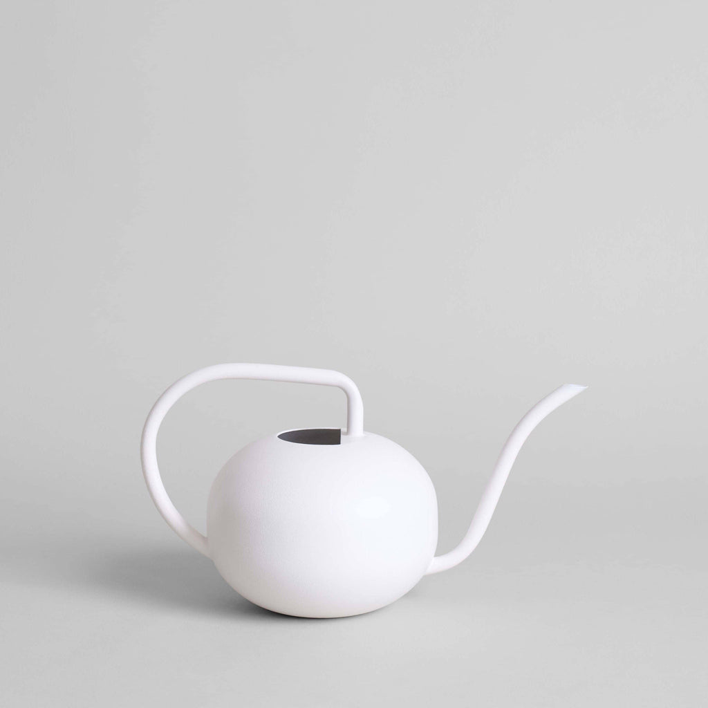 The Beatrix Watering Can: White by Bloomist features a handcrafted spherical body, curved handle, and long spout, highlighting modern design against a light gray background.