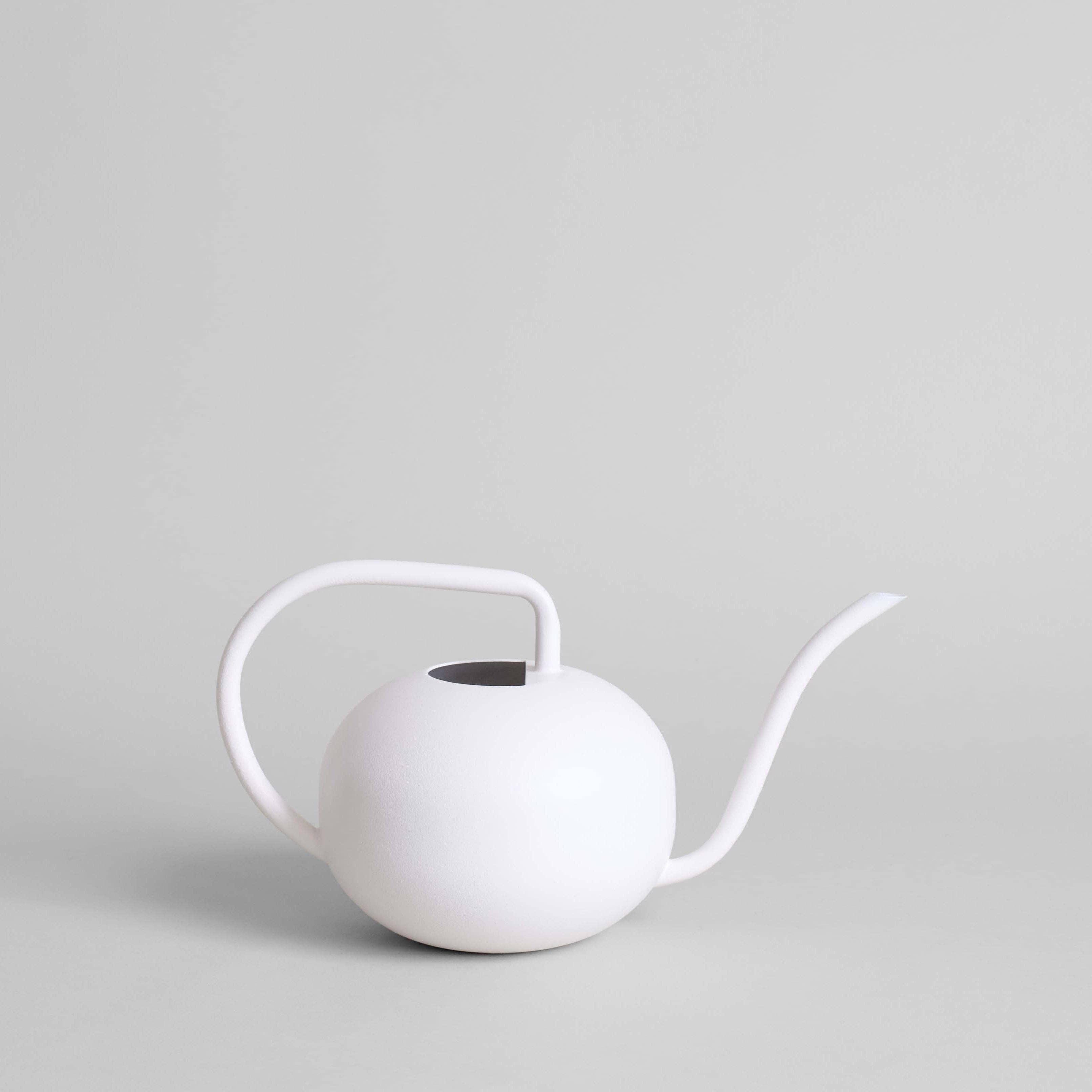 The Beatrix Watering Can: White by Bloomist features a handcrafted spherical body, curved handle, and long spout, highlighting modern design against a light gray background.
