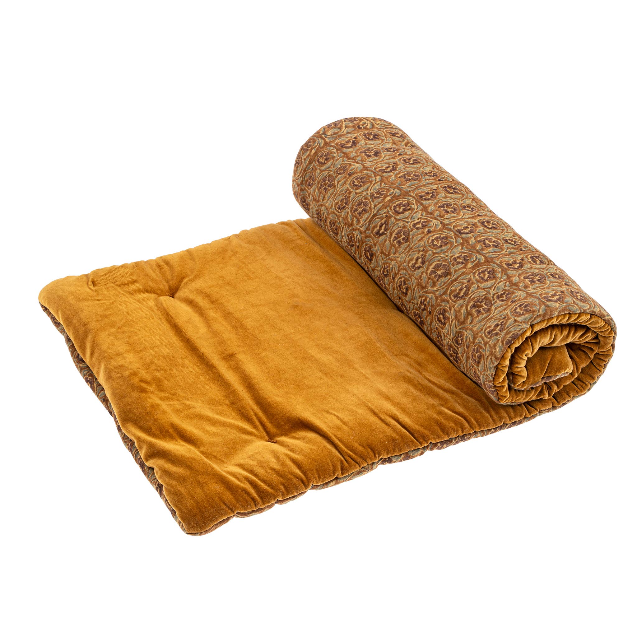 The Mayur Block Print Velvet French Mattress by Indaba Trading features a mustard yellow padded cotton mat, partially rolled to reveal an intricate brown and beige pattern, adding luxurious comfort inspired by classic French style.