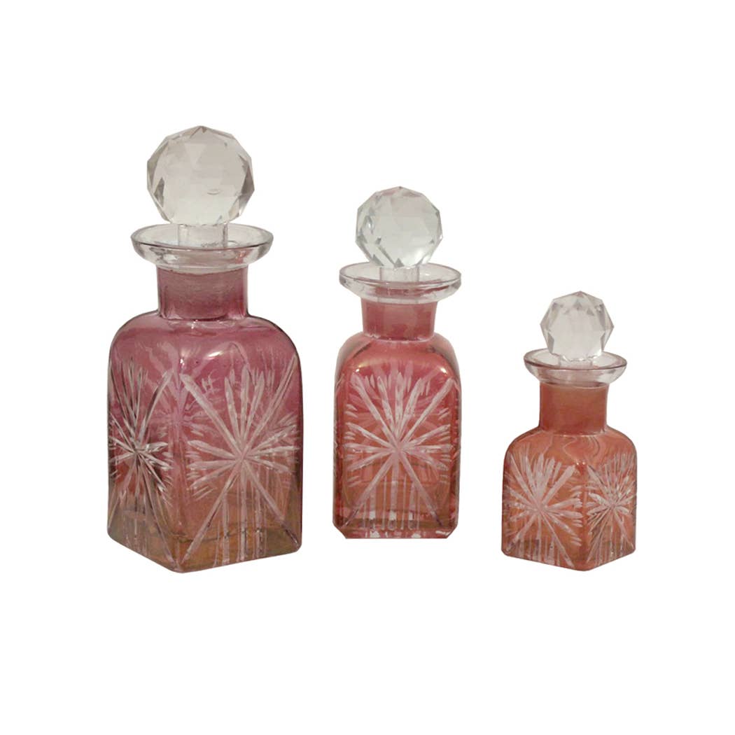 Set of three Reproduction Victorian Hand-Cut Rose Glass Perfume Bottles by Madison Bay Co., featuring faceted stoppers and elegant etched starburst patterns in varying sizes. Perfect for historical home decor.