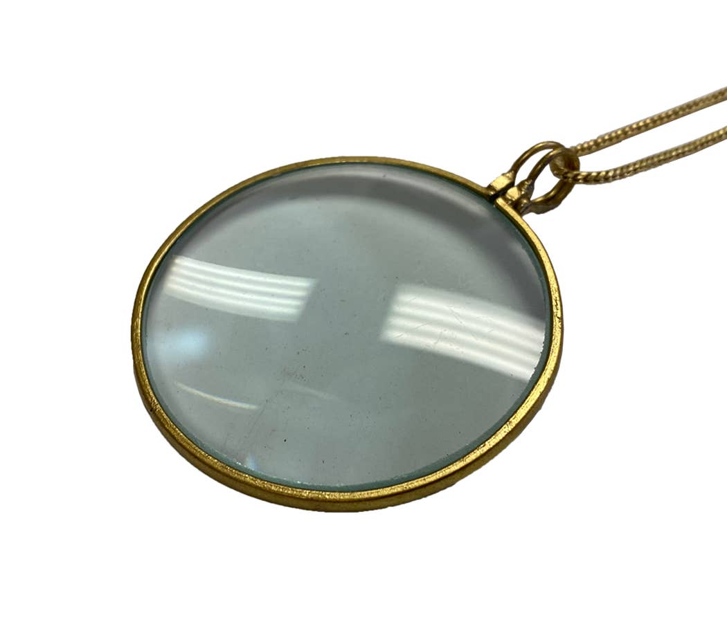 The Madison Bay Co. Magnifying Glass on Necklace (Antique Reproduction, 1-3/4") features a round lens in a gold-tone frame on a thin brass rope chain—an elegant alternative to progressive readers.