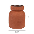 The HomArt Kosta Vase, Terra Cotta Cement - Short, features a rustic, unglazed textured brown geometric design with a wide round body and narrow neck. It measures 8" tall by 6.25" wide.