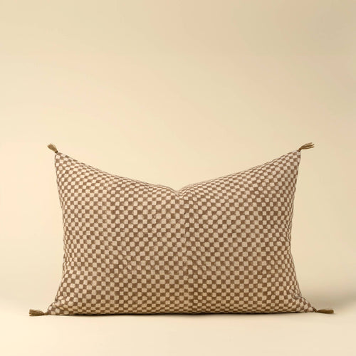 The Indaba Trading 16x24 Block Print Check Linen Pillow, Brown, features a beige and brown checkerboard pattern with small corner tassels; includes cover with filler.