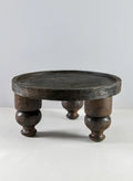 The Jamali Garden 14in Wide Banjara Reclaimed Look Deep Brown/Black Rugged Wood Stand features a round silhouette with a raised edge and three sturdy, turned legs, shown against a plain, light gray background.