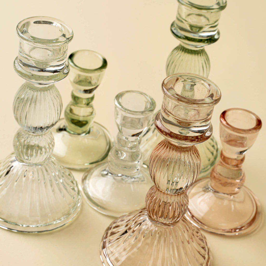 The Indaba Trading Callista Glass Candleholder Large in Blush features elegant ribbed glass in a pastel pink hue, perfect for vintage-inspired decor and adding a stylish accent to any surface.