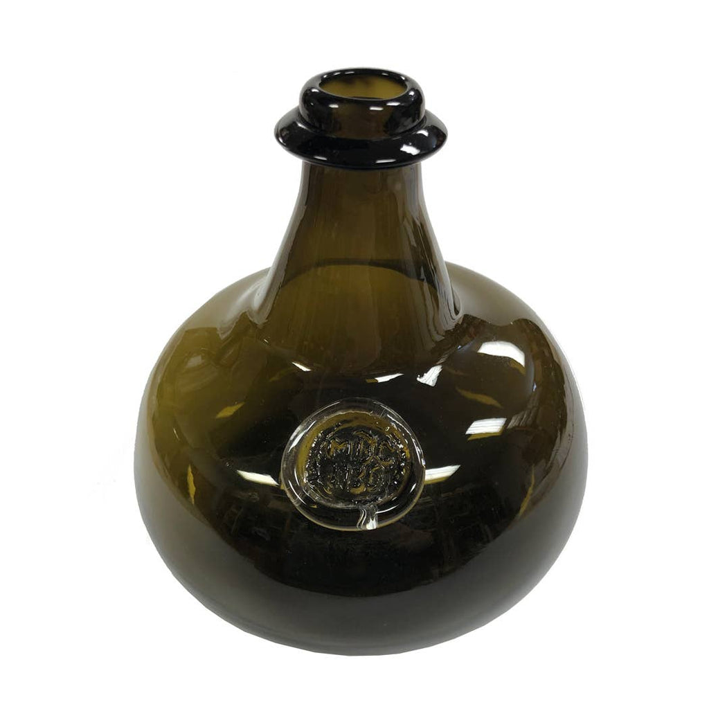 The Madison Bay Co. Hand-Blown Dark Green 76-oz. Onion Bottle (8”) is an antique reproduction with a wide, round body, short neck, flared lip, and comes embossed with a circular seal on the side.