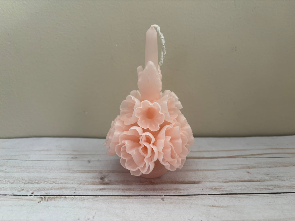A pale pink Carnation Oaxaca Marigold Day of the Dead Candle shaped like a cluster of layered flowers with a centered wick.