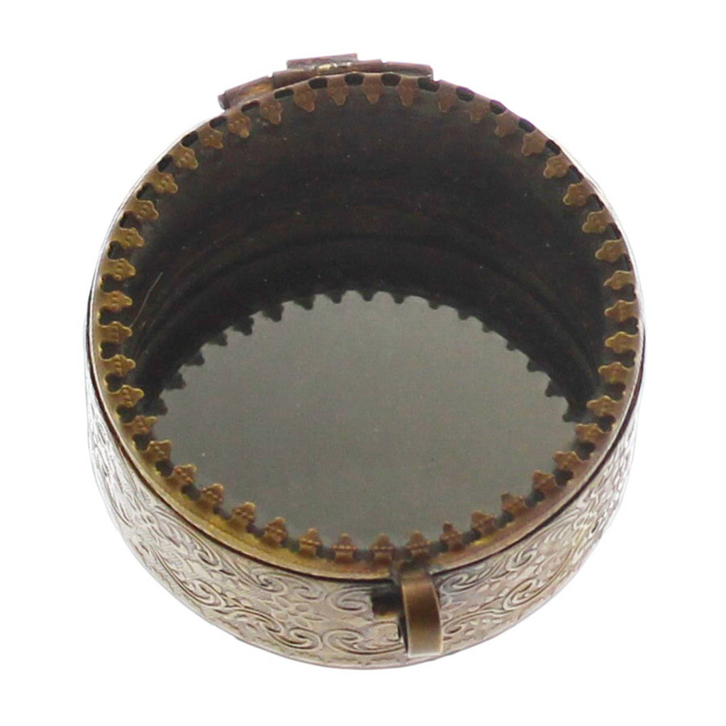 The HomArt Josephine Mirrored Box, Brass - Sm Round, features intricate side engravings, a hinged glass lid, and an inner rim with evenly spaced teeth-like details.